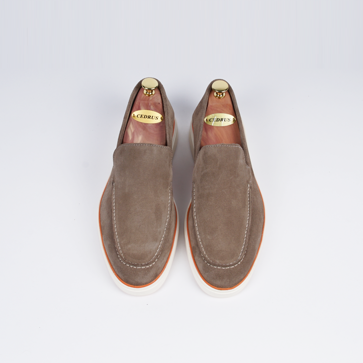 Close-up van de neus van de beige loafer, met fijn handwerk en elegant design.
