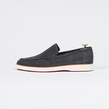 Zijaanzicht van de grijze suède loafer, gemaakt van premium materialen.