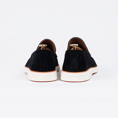 Close-up van de hiel van de zwarte loafer, met een subtiele afwerking.
